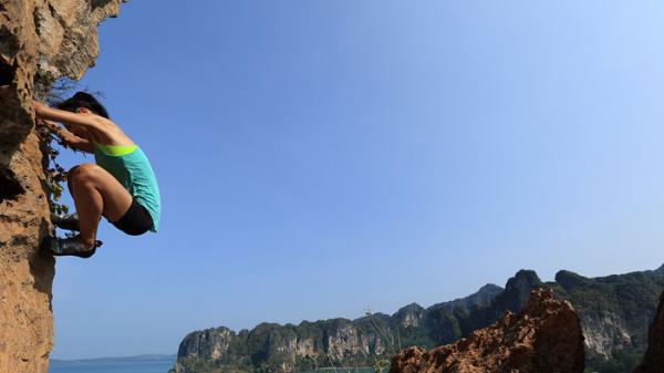 Woman climbing a rock